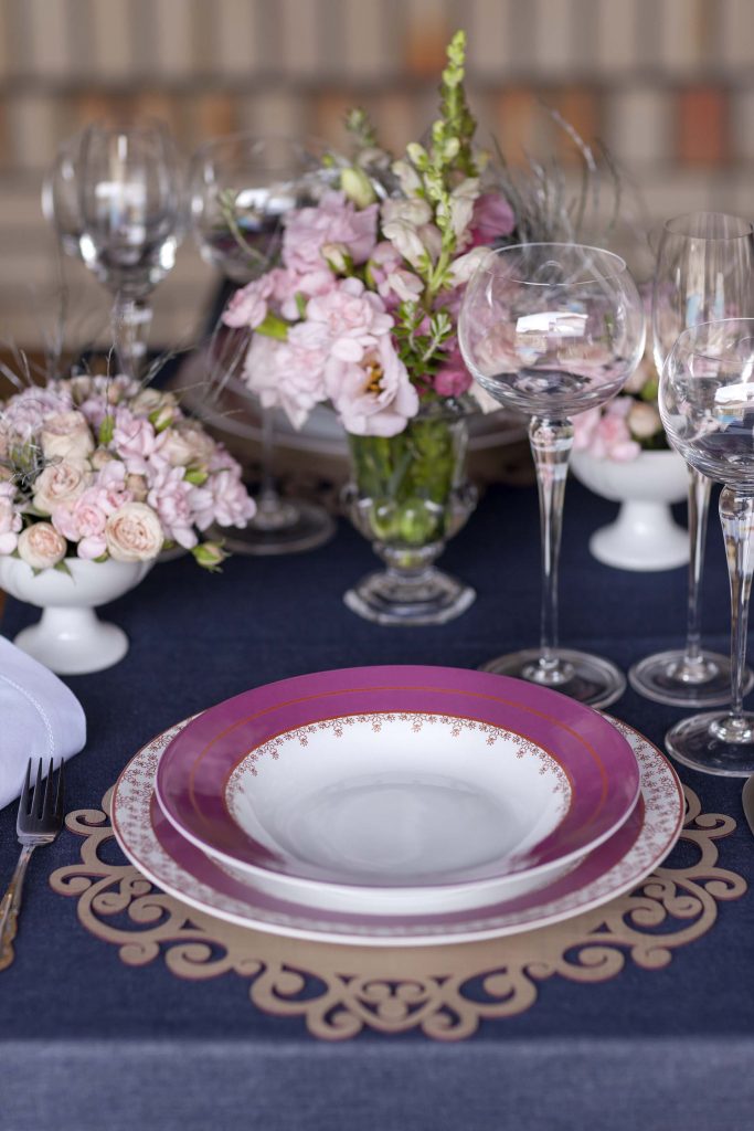 A partir da escolha da louça rosa, a opção pelo trilho jeans e sousplat de couro cru foi para destacar a porcelana. Foto: Raphael Günther/Bespoke Content. Imagem: A partir da escolha da louça rosa, a opção pelo trilho jeans e sousplat de couro cru foi para destacar a porcelana. Foto: Raphael Günther/Bespoke Content.