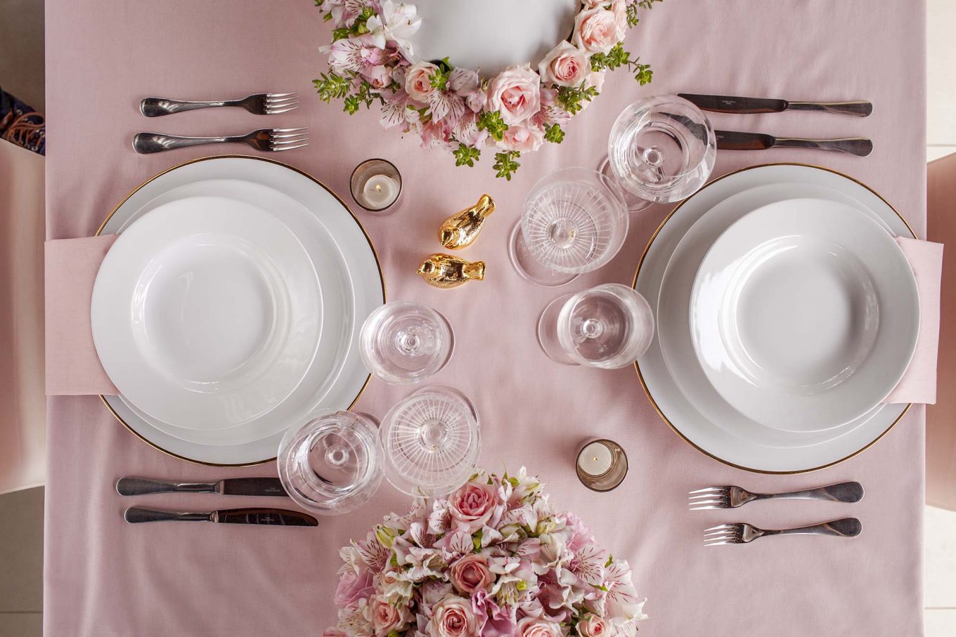Para refinar a louça branca, foi usado um sousplat de porcelana com filete dourado, velas e taças de cristal. Foto: Raphael Günther/Bespoke Content. Imagem: Para refinar a louça branca, foi usado um sousplat de porcelana com filete dourado, velas e taças de cristal. Foto: Raphael Günther/Bespoke Content.