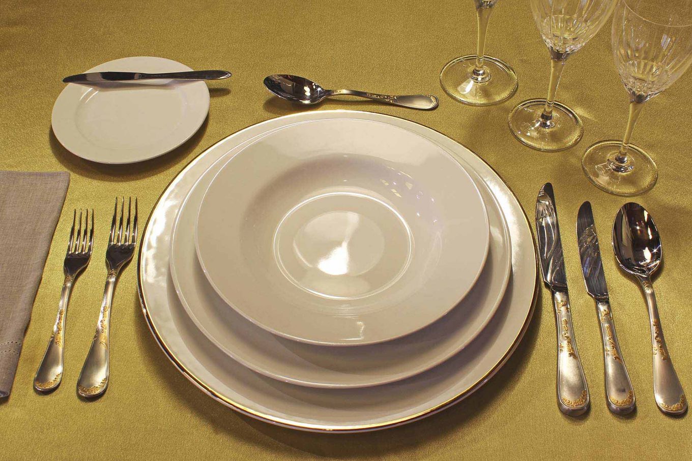 Imagem: O sousplat branco com filete dourado fica muito bem com os pratos brancos Flamingo White da Oxford Porcelanas.