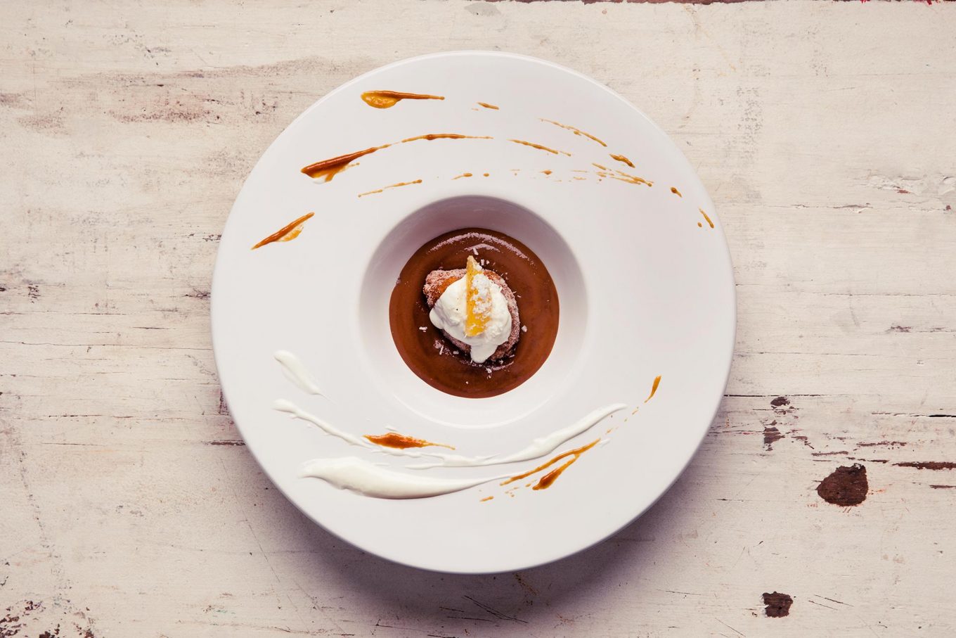 Imagem: O prato de entrada servindo a sobremesa: creme de caramelo com bolinho de chuva.