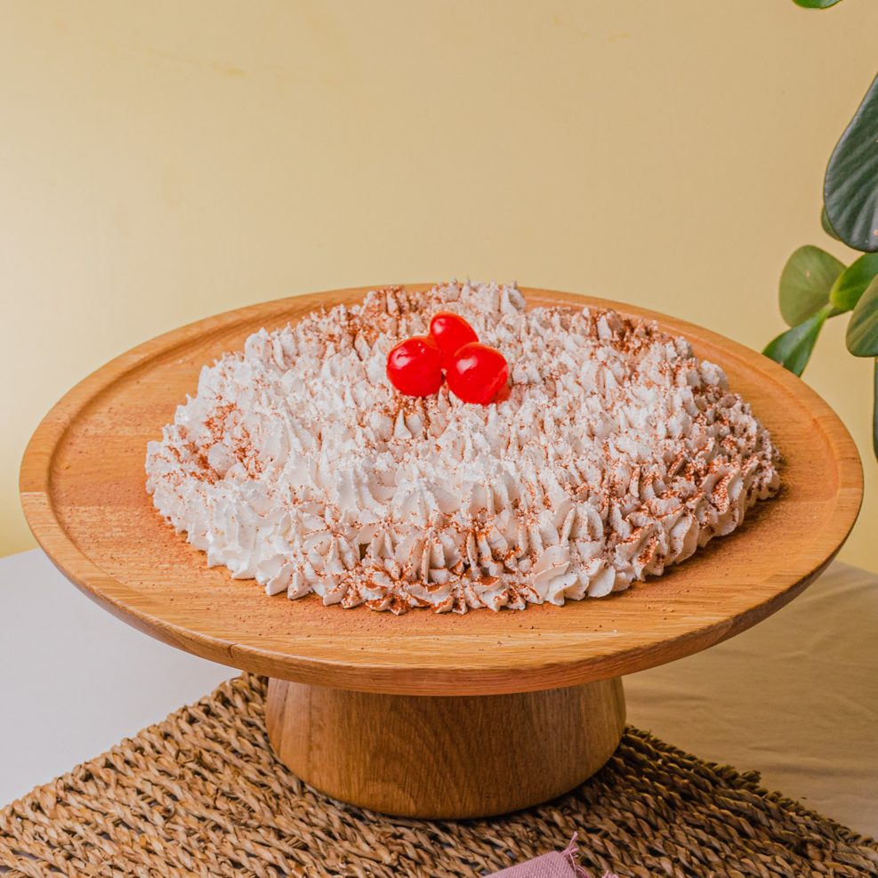 Imagem: torta banoffe servida em boleira de madeira. 