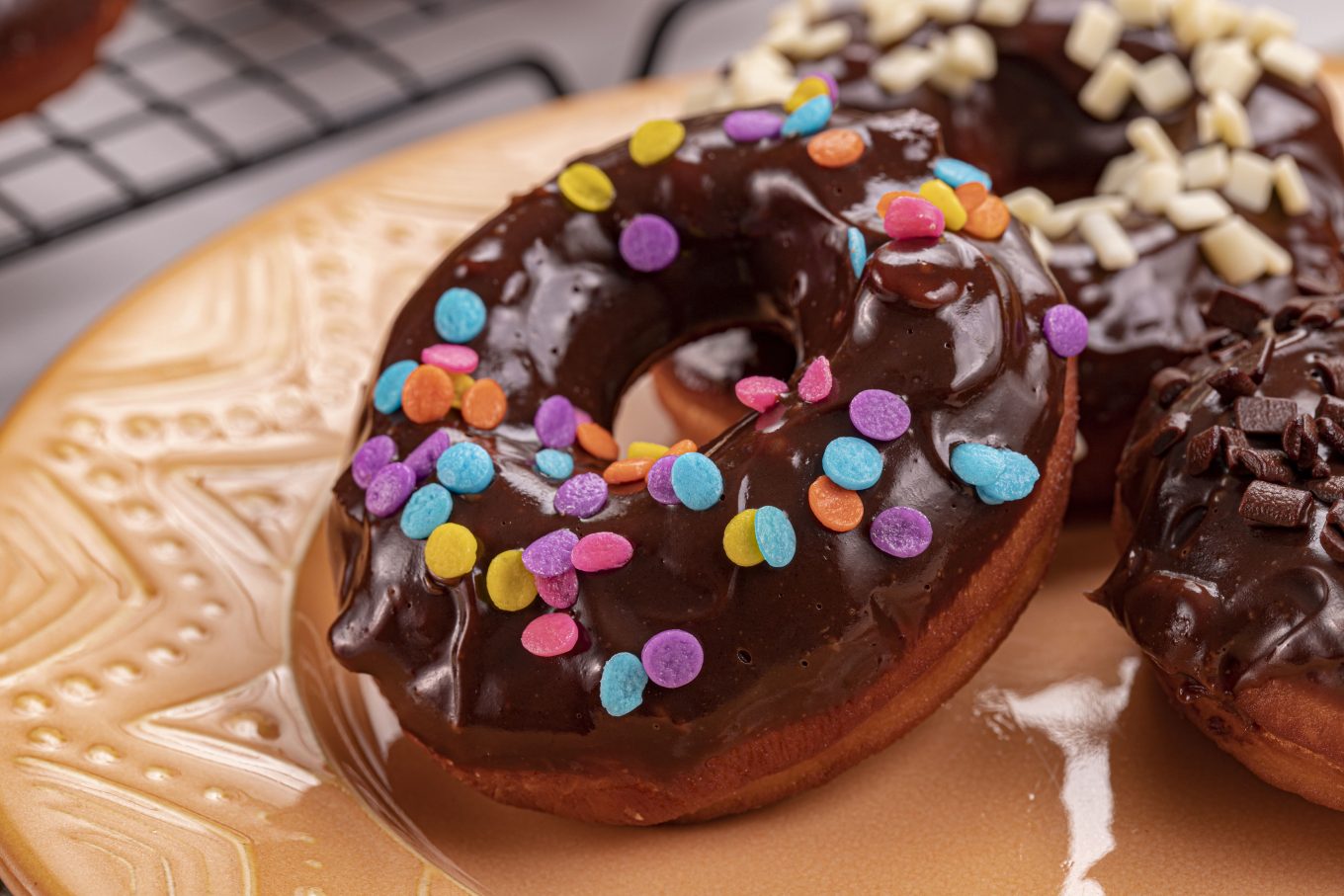 Imagem: donuts coloridos servidos em prato laranja