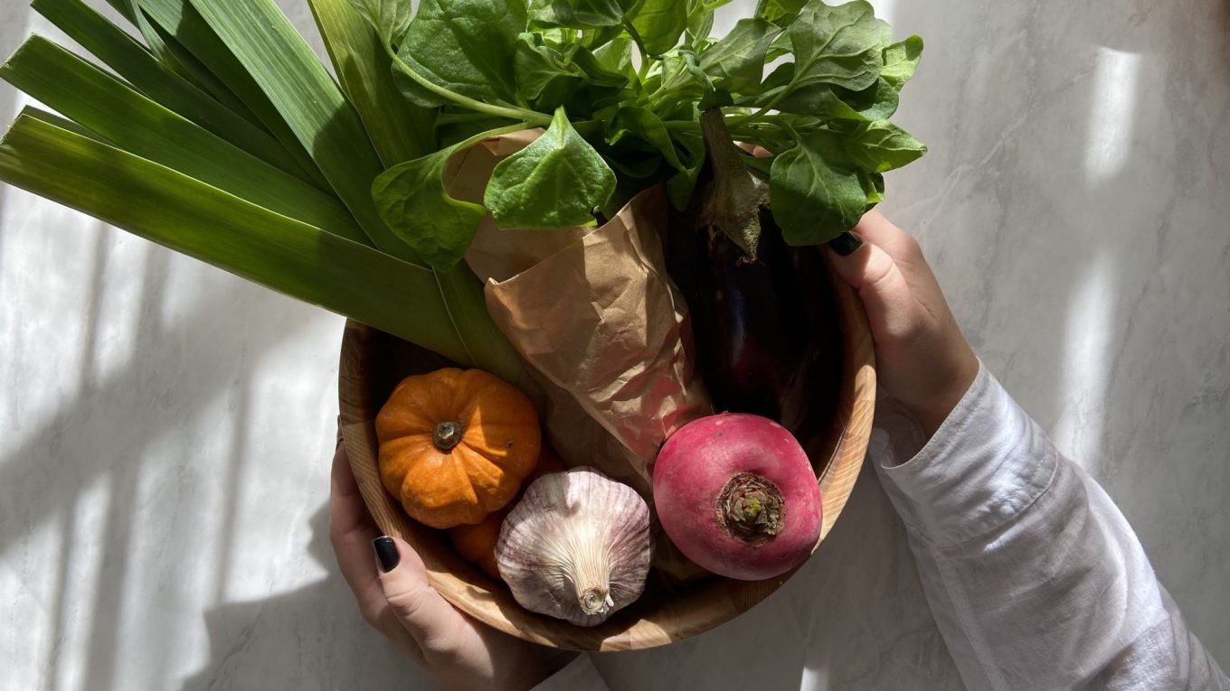 Verduras da estação em uma bacia de madeira.