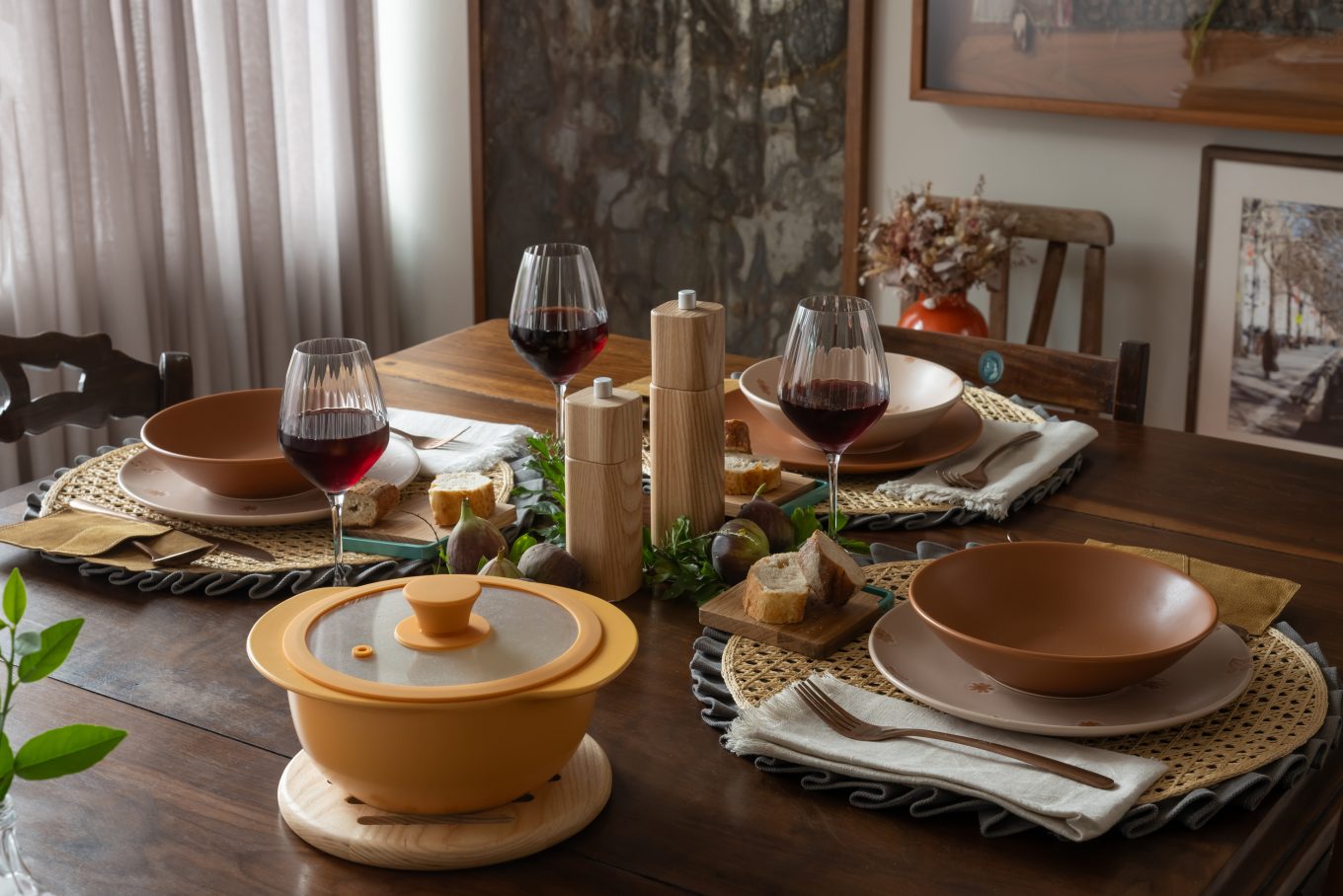 Imagem: mesa de inverno com pratos fundos e panela com sopa.