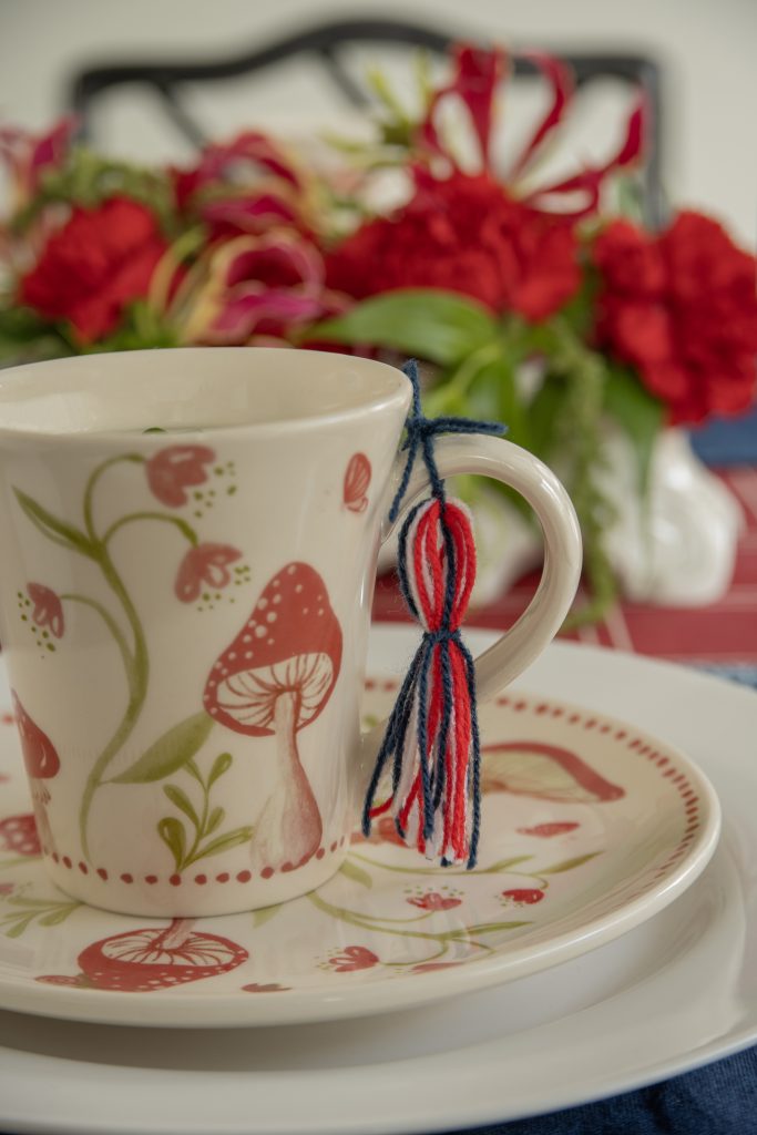 Imagem: caneca sobre prato de sobremesa, ambos decorados com cogumelos. 